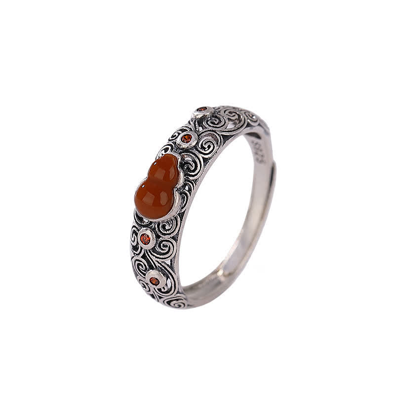 Red agate sterling silver gourd ring with carved scroll band displayed on pure white background