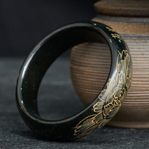 Hand-carved cyan jade bangle featuring traditional peony motifs and Chinese calligraphy, side angle