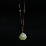 Hetian jade prosperity pendant necklace with small bag charm, light green rounded jade stone on yellow cord with gold and brown wooden spacer beads, front view