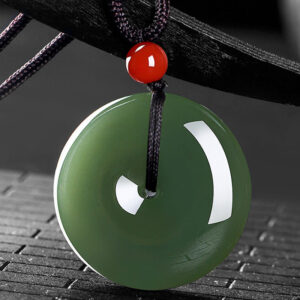 Round jade peace buckle pendant top-down view showing polished surface and white inner ring pattern, traditional Chinese craftsmanship