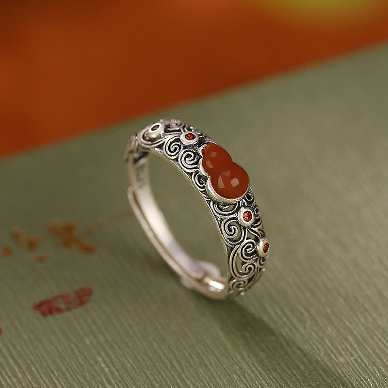 925 sterling silver red agate gourd ring with adjustable open band on retro calligraphy fabric background