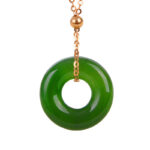 Cyan jade donut pendant necklace with rose gold chain on white background, showcasing polished turquoise-green stone healing properties