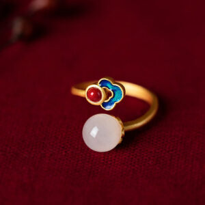 White jade auspicious cloud ring with copper-plated silver band featuring traditional cloisonné cloud design and round jade pendant on dark red velvet backdrop