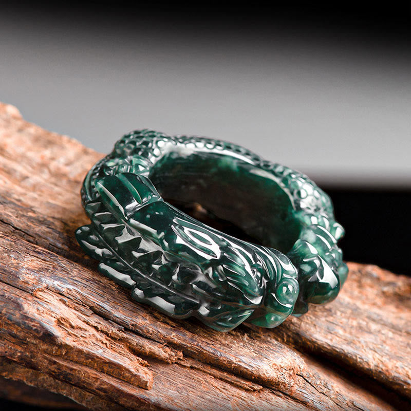 Top-down angled side view of cyan jade dragon ring with dual dragon head details and thick polished band