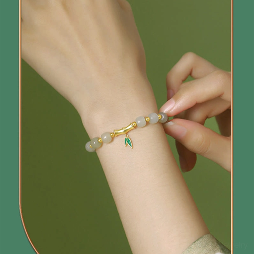 Close-up interaction shot of hands adjusting Hetian jade bamboo bracelet on wrist during wear