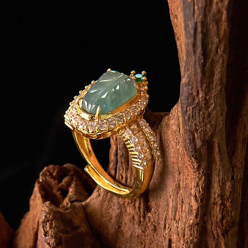 Adjustable jade leaf ring low angle view showing the open adjustable band design and carved jade stone on gold-plated metal