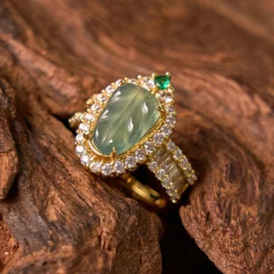 Jade leaf adjustable luck ring flat lay top-down view highlighting the diamond accent halo and gold-toned metal band