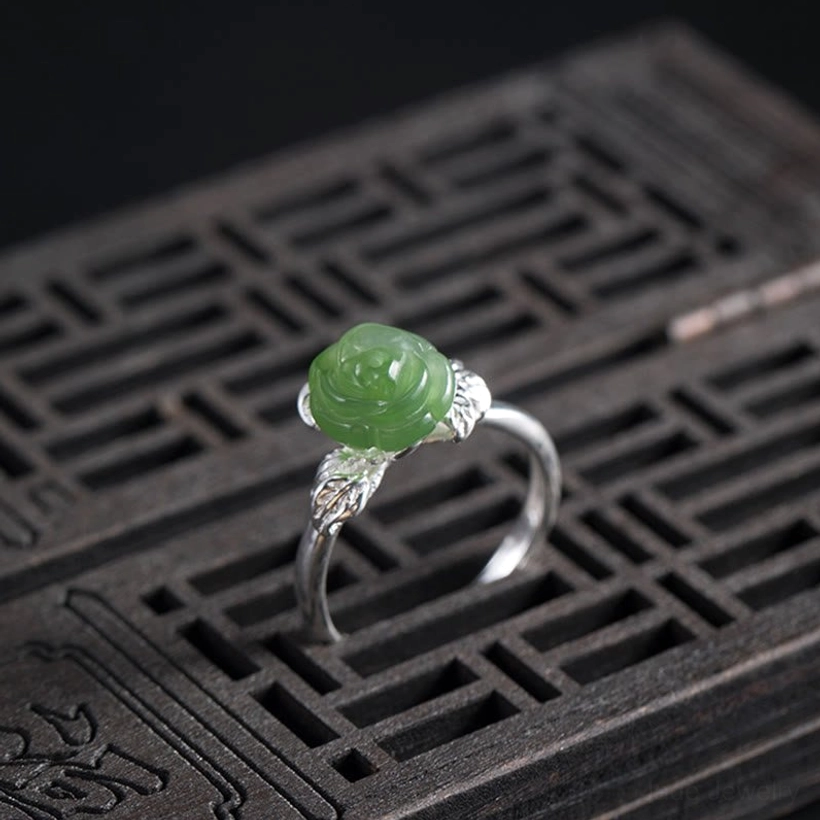 Adjustable jade rose ring band opened to show flexible sizing mechanism and detailed silver leaf work