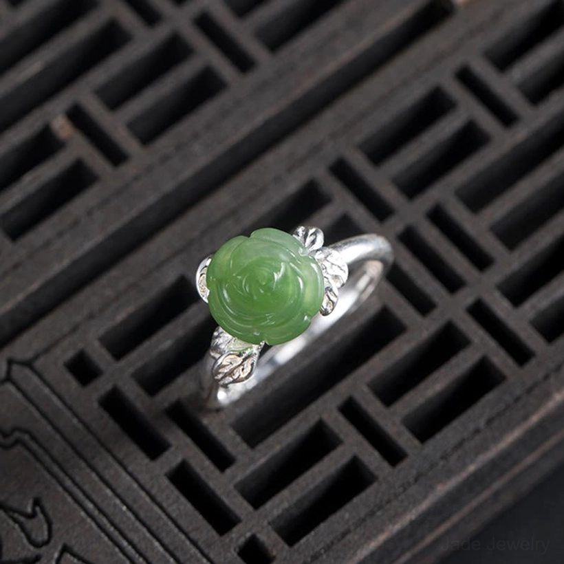Top-down view of adjustable jade rose ring displaying open band flexibility and intricate silver leaf designs