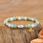 Amazonite white agate butterfly healing bracelet with gold gourd charm on wooden table with dried flowers