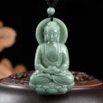 Amitabha Buddha jade pendant front view carved with lotus base and celestial halo on dark wooden stand