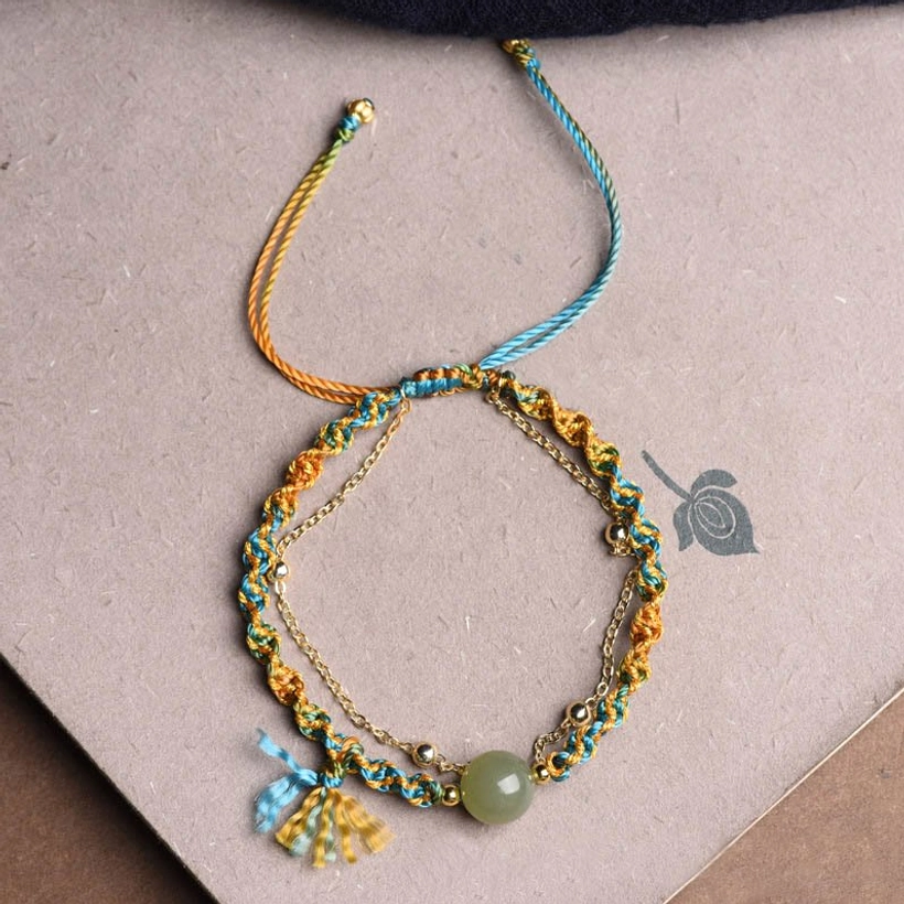 Artisanal double layer jade luck bracelet with colorful rope and decorative tassel pendant