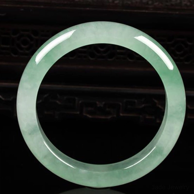 Authentic jade bangle bracelet front view with even light green jade texture and polished finish
