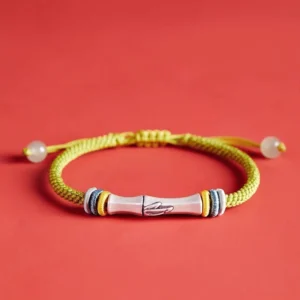 Red braided sterling silver bamboo bracelet centered on red backdrop, front product view