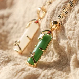 Close-up of handcrafted bamboo jade pendant necklace showing intricate gold filigree bail and gemstone detail