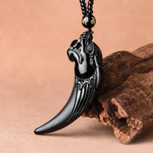Hand-carved black jade dragon tooth necklace showing detailed grain texture and matte finish, beaded cord with engraved mantra bead