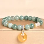 Blue jade peace buckle beaded bracelet with white pearls and yellow jade pendant displayed on beige jewelry tray, featuring gradient green jade beads
