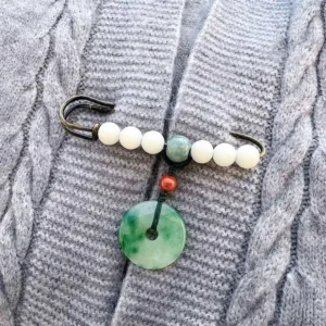 Bodhi seed jade peace buckle brooch with white jade beads and green jade pendant on grey cable-knit sweater