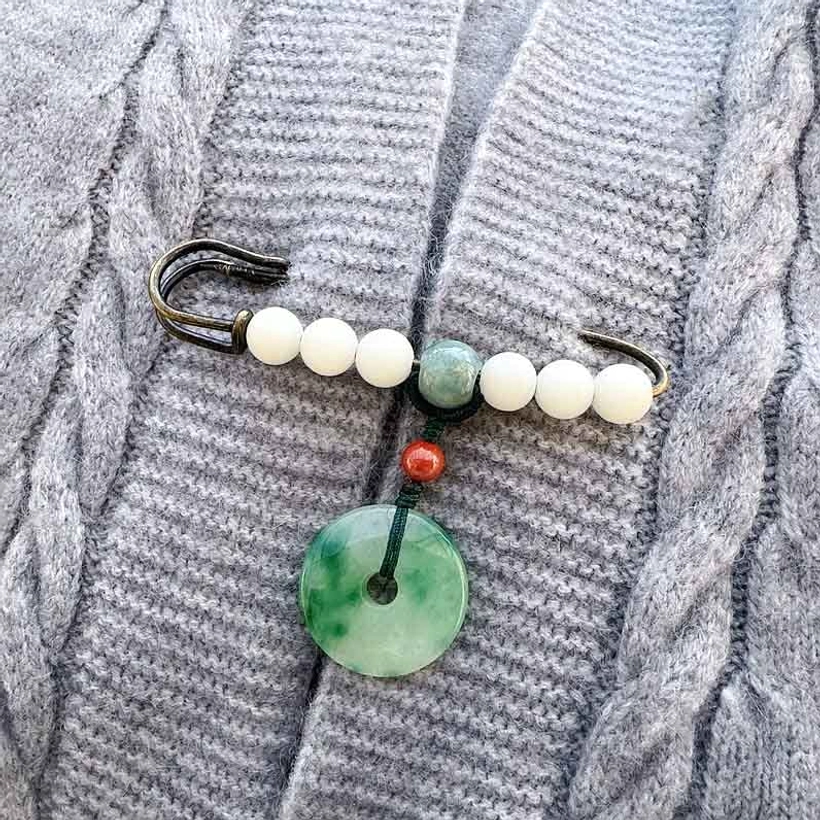 Bodhi seed jade peace buckle brooch with white jade beads and green jade pendant on grey cable-knit sweater