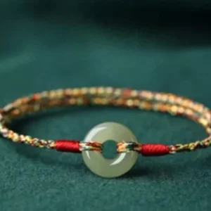 Braided jade peace buckle bracelet with twisted multicolor cord showing red and multicolor rope segments, side view