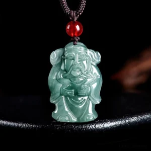 Natural green jade Caishen God of Wealth pendant necklace with brown cord and red accent bead - front view on black display