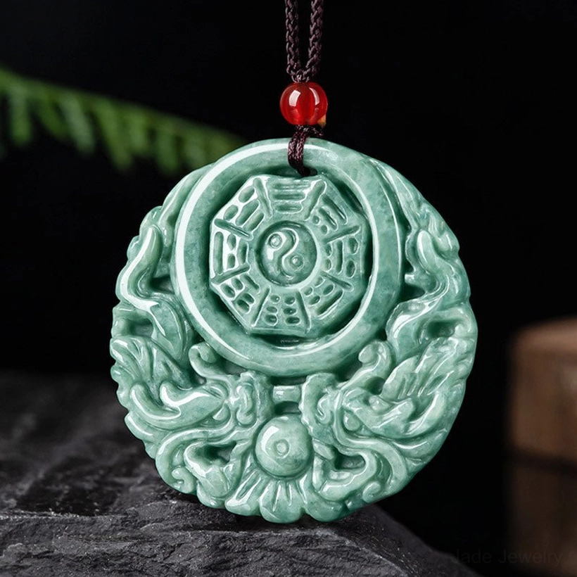 Detailed close-up of hand-carved jade pendant showing intricate dragon and yin yang motifs