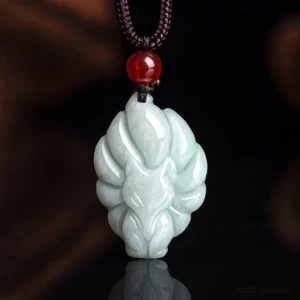 Natural celadon jade nine-tailed fox pendant necklace with red agate bead and brown cord - detailed studio close-up featuring intricate hand-carved fox design
