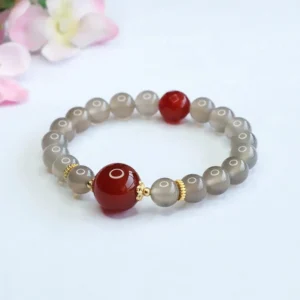 Natural gray chalcedony beads with vibrant red agate accents and gold metal spacers overhead view