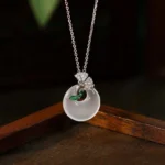 Natural chalcedony ginkgo leaf peace buckle necklace pendant close-up on wooden display
