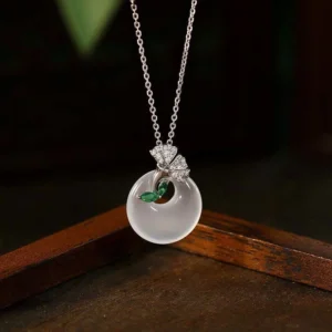 Natural chalcedony ginkgo leaf peace buckle necklace pendant close-up on wooden display