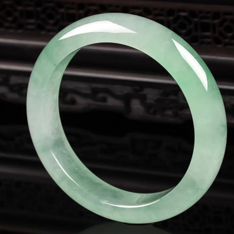 Classic jade bangle bracelet flat lay displaying uniform light green tone and traditional round bangle shape