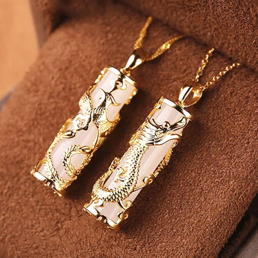 Couple's dragon and phoenix jade pendant set displayed together in brown suede jewelry box, symbolic gift presentation