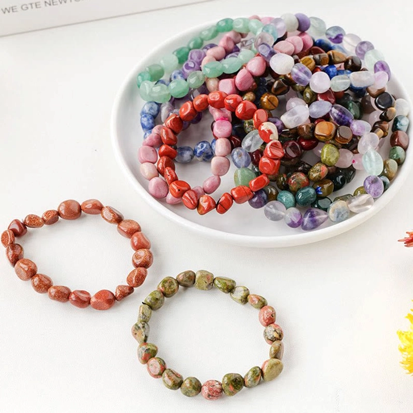 Crystal stone beads and bead plate display with individual natural stone bracelets on white background