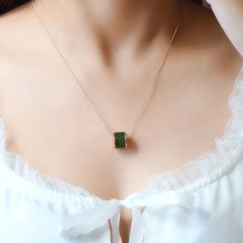 Ultra-thin gold chain cyan jade barrel pendant necklace close-up on collarbone, elegant minimalist necklace styling