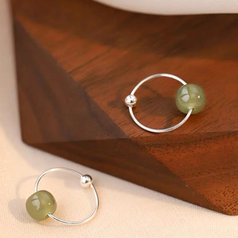 Cyan jade bead sterling silver hoop earrings - top-down flat lay with multiple pieces showing glossy round cyan jade beads on polished silver