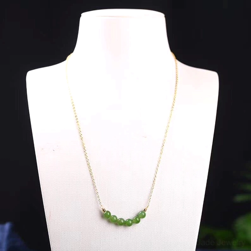 Hetian cyan jade necklace worn on studio display mannequin at neck level showing proper styling with thin 14K gold-plated chain and arc-shaped jade bead pendant - jade necklace wearing guide