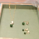 Complete cyan jade butterfly jewelry set including necklace, adjustable ring, and stud earrings with Tridacna stone accents displayed on green velvet jewelry tray