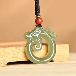Cyan jade dragon pendant close-up detail hollow carved spiral motif with red accent bead on adjustable black cord