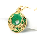 Cyan jade dragon phoenix pendant necklace with gold embossed details, three-quarter view on white background