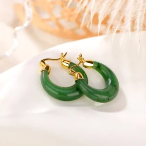 Natural cyan jade earrings featuring authentic mineral speckles, angled flat lay showcasing jade color and texture