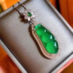 Cyan jade fortune bean pendant necklace displayed in luxury silver jewelry gift box with floral gemstone clasp