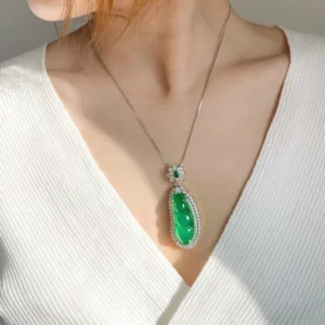 Cyan jade luck necklace worn on neck and collarbone with white knit top, delicate silver chain pendant