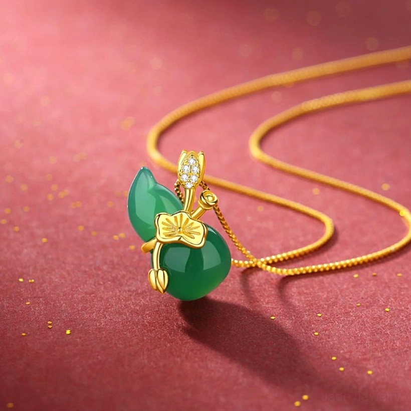Cyan jade gourd lotus pendant necklace with gold chain on red background with golden glitter, featuring crystal-accented bail