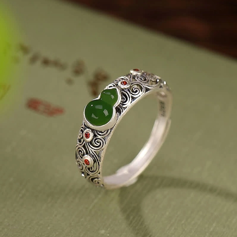 Cyan jade sterling silver gourd ring with scroll-carved band on retro calligraphy fabric showcase