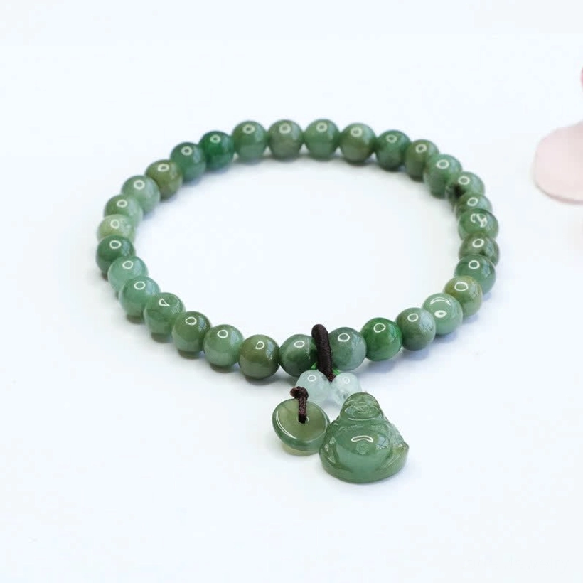 Cyan jade laughing Buddha bracelet with smooth round jade beads and hand-carved Buddha pendant on elastic string, flat lay view