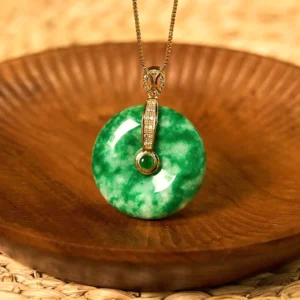 Cyan jade peace buckle necklace front view on wooden tray displaying natural marbled green jade with diamond-adorned gold bail
