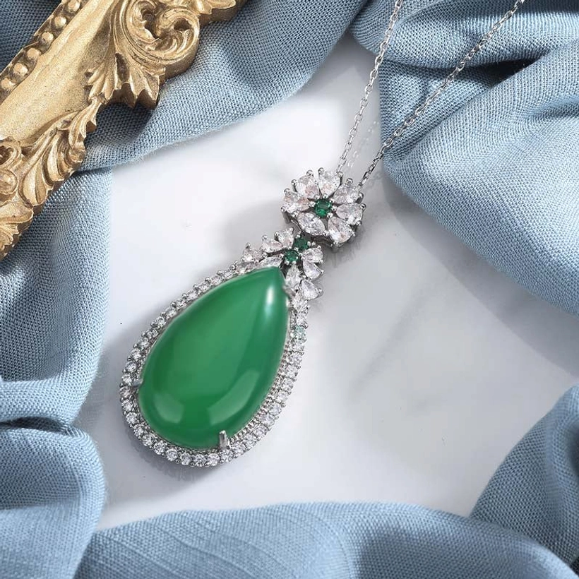Side profile view of cyan jade teardrop pendant necklace, showing floral gem setting details and elegant stone shape