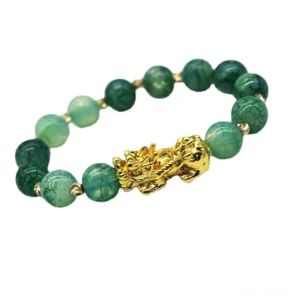 Cyan jade Pi Xiu wealth bracelet handmade flat lay overhead view with gold charm on dark background