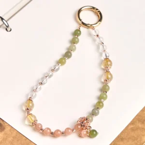 Cyan jade and clear quartz beaded phone lanyard with rose gold hardware, flat lay desktop view