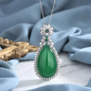 Cyan jade teardrop pendant necklace with pavé stone setting, front close-up view showing luminous green jade stone encircled by delicate gems